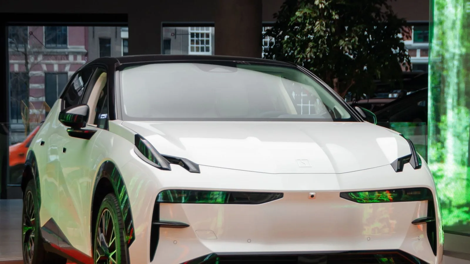 White electric car on display in a modern showroom